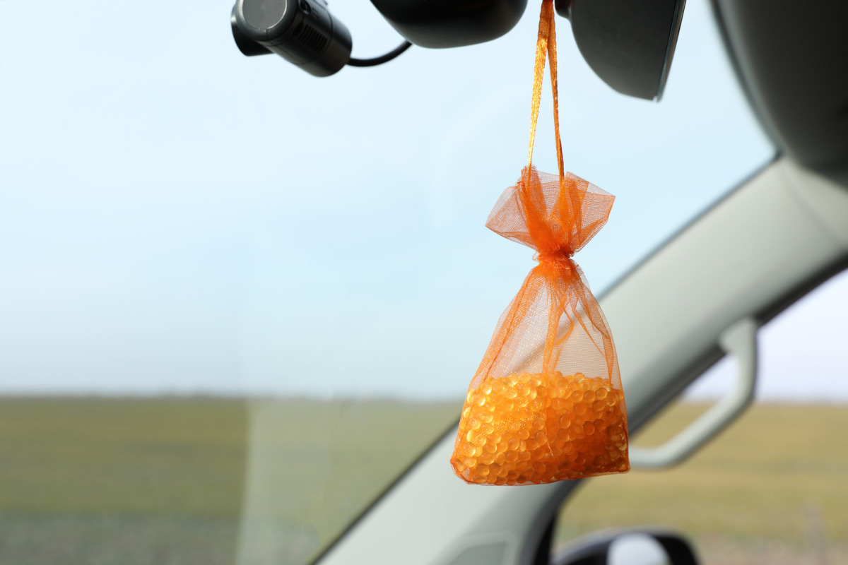 Air freshener hanging in car against windshield. Space for text