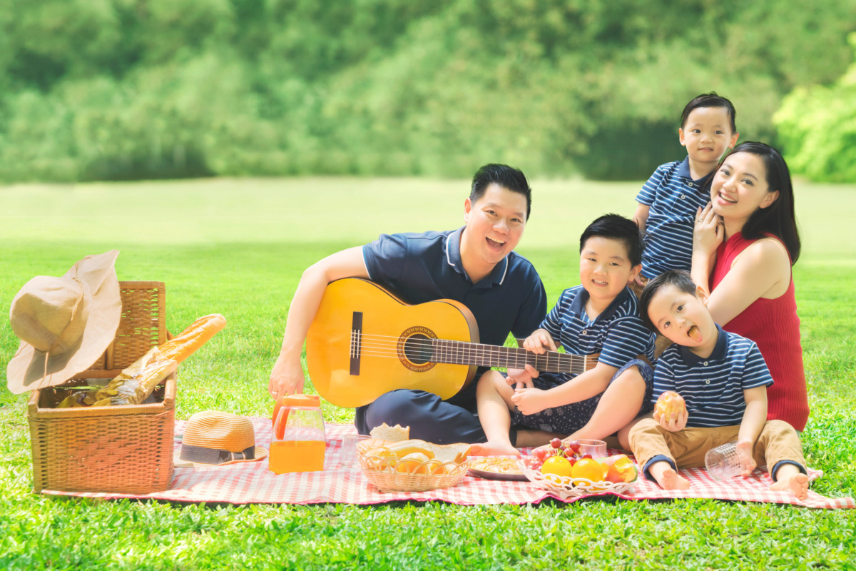 Chinese family playing a guitar in the park