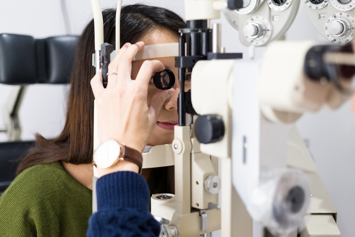 Woman look in ophthalmoscope to determine diopter in clinic